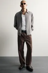 Pantalón jeans de corte relaxed fit, color celeste con efecto lavado, de estilo carpintero con bolsillos laterales y presillas de herramientas.