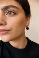 Aros de argolla en acero quirúrgico con dije de piedra natural en tono azul.