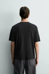 Camiseta de corte relaxed fit, confeccionada en mezcla de algodón y lino, con cuello redondo y mangas cortas.