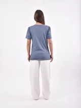 Remera azul con estampado de estrellas blancas, cuello redondo y mangas cortas con frunce en los hombros.