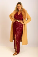 Vestido largo de fiesta color rojo con lentejuelas, escote en V, corte cruzado, cinturón dorado con hebilla circular y tajo lateral. Incluye abrigo color camel con cuello de piel sintética.