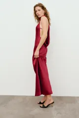 Vestido largo de satén color lila, con cuello halter y diseño fluido.