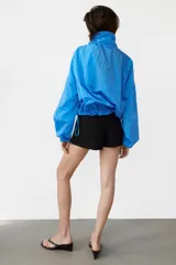Shorts mini de tiro bajo en color negro, con bolsillos de plastrón en el delantero y cierre lateral con cremallera oculta.