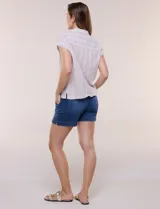 Camisa de lino de estructura recta, color beige con rayas verticales blancas. Cuenta con cuello solapa, escote en V abierto, abotonadura frontal, bolsillo plaqué en el pecho, mangas cortas de hombro caído y ruedo recto.