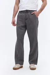 Pantalón de corte relajado y silueta amplia, confeccionado en algodón con acabado lavado. Presenta un diseño clásico de cinco bolsillos y costuras reforzadas en los laterales.