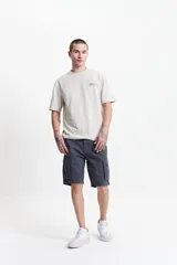 Bermuda cargo de corte clásico en color beige, con bolsillos laterales tipo cargo, cierre de cremallera y botón, y pasacintos.