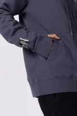 Buzo canguro de friza en color azul grisáceo, con capucha, cordones ajustables, bolsillo frontal tipo canguro y estampado pequeño en el pecho con el texto VCP CNPT.