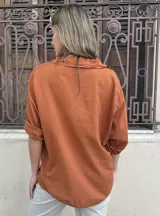 Blusa clásica de fibrana en color caramelo, con cuello en V, mangas largas y diseño holgado.