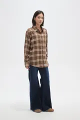Camisa de algodón con estampado de cuadros en tonos marrones y blancos, de corte holgado, manga larga y cierre frontal con botones.