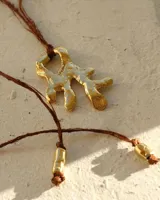 Collar con dije de bronce macizo con forma orgánica irregular, similar a un coral, suspendido de un cordón negro de seda natural anudado.