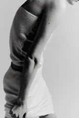 Falda midi de tejido ligero color crema o beige muy claro, con cintura elástica de color beige más oscuro. El bajo está adornado con una aplicación de encaje floral a tono.