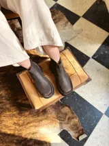 Bota Chelsea de cuero color marrón chocolate con elástico lateral negro y suela track color negro.