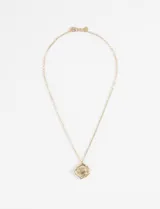 Collar dorado con dije irregular con textura.