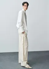 Pantalón de diseño balloon con cintura elástica, tiro medio y pinzas en el bajo. Presenta una textura ligeramente arrugada y forro interior.
