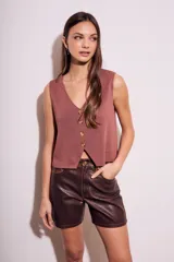 Short marrón de cuero sintético, tiro medio y corte recto.