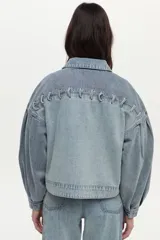 Campera de denim de algodón con diseño boxy, mangas abullonadas y detalles de cordones trenzados en la parte frontal.