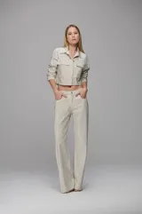 Pantalón de sarga color off-white con corte recto y tiro bajo. Presenta una aplicación integral de mini cristales brillantes, bolsillos laterales y bolsillos traseros geométricos.
