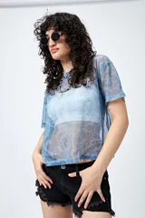 Top de manga corta, corte holgado, confeccionado en tejido de malla translúcido con brillo metálico y estampado tipo paisley en tonos azules.