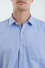 Camisa celeste de vestir, de manga larga, con cuello clásico y bolsillo en el pecho.