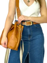Bolso tote color marrón cuero, confeccionado en cuero genuino, con doble asa de mano y correa bandolera de tela con rayas beige y marrón.