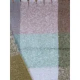 Bufanda rectangular de tejido grueso con diseño de cuadros en tonos azul, naranja, gris y beige, terminada con flecos en los extremos.