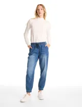 Pantalón tipo jogger de denim azul con efecto lavado. Presenta cintura elástica con cordón ajustable, bolsillos laterales y traseros, y puños elásticos en los tobillos.
