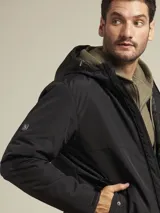 Campera negra con capucha, cierre frontal y bolsillos laterales con botón a presión.
