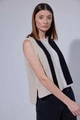 Chaleco de tejido de punto con diseño de bloques de color en tonos tierra, incluyendo marrón, verde oliva y beige. Presenta un panel central con textura tejida y cuello redondo.