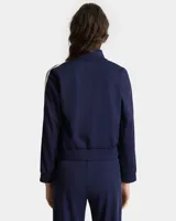 Campera deportiva azul marino con cierre frontal, cuello alto, puños y bajo acanalados. Presenta logo bordado en el pecho y detalle de rayas blancas en las mangas.