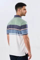 Remera polo de manga corta con diseño a rayas horizontales en tonos beige, celeste, rosado, azul marino y verde. Cuenta con cuello polo y cierre frontal con botones.
