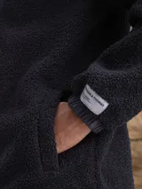Campera con capucha confeccionada en una combinación de tejido técnico y sherpa, con cierre frontal completo y puños elásticos.