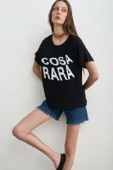 Remera negra de algodón con estampa frontal con la leyenda "COSA RARA" en color blanco, de corte holgado y mangas cortas.