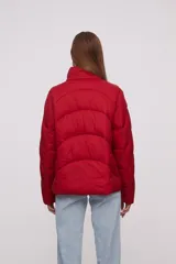 Campera roja de poliéster con diseño acolchado, cierre frontal con cremallera y cuello alto.