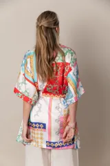 Kimono italiano de satén estampado con motivos geométricos y florales en tonos rojo, azul, naranja y dorado. Incluye lazo de ajuste en la cintura.