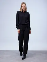 Pantalón de vestir de corte wide leg color negro, con cintura alta, detalle de botones decorativos en la parte frontal y bolsillos laterales.