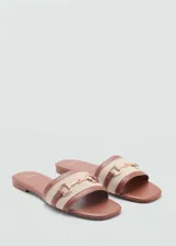 Sandalias planas destalonadas con tira en el empeine de lino color crudo y bordes de poliuretano marrón, decoradas con un detalle metálico dorado.