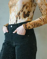 Body de tul ajustado con estampado animal print, escote redondo y mangas largas.