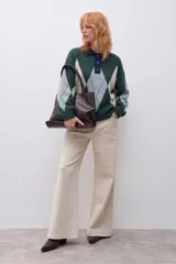 Sweater de tejido de punto con diseño de rombos en tonos verde inglés, gris y beige. Presenta cuello polo con cierre de botones, mangas largas y corte holgado.