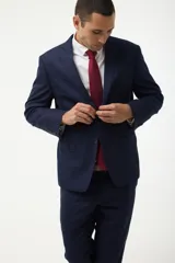 Ambo formal compuesto por saco de dos botones con solapas clásicas y bolsillos con solapa, y pantalón de vestir a juego, confeccionado en tela de alta calidad color azul marino.