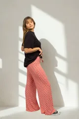 Pantalón oxford de tela con spandex, color rosa con lunares rojos, con cintura elástica.