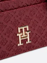 Tarjetero Tommy Hilfiger color borgoña con monograma TH en bajo relieve, compartimento con cremallera y múltiples ranuras exteriores para tarjetas.