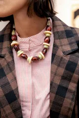 Collar corto de cuentas de resina en tonos marrón rojizo, verde claro y beige, con diseño de esferas y discos intercalados.
