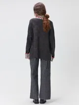 Pullover de punto jacquard con diseño de cuadros en relieve, cuello alto y mangas largas. Presenta detalles de pespuntes en color rojo en el cuello y los puños, aberturas laterales y logo bordado en el pecho.