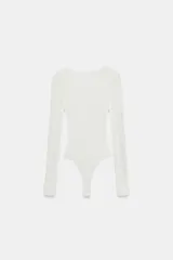 Body de encaje blanco con cuello redondo y mangas largas, con diseño de espalda descubierta.