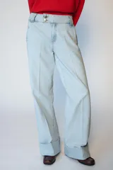 Jeans de tiro bajo con pernera recta y bajo con vuelta. Presenta bolsillos delanteros, bolsillos de plastrón en la parte trasera y cierre frontal con cremallera y botones.