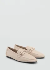 Mocasín color beige de cuero con detalle de hebilla metálica dorada.