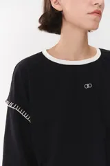 Remera de manga larga con corte oversized, color azul marino con cuello redondo en contraste color marrón. Presenta costuras decorativas a contratono hechas a mano en la zona de los hombros y logo bordado en el centro del pecho.