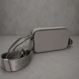 Cartera tipo bandolera de diseño rectangular y estructura rígida, color gris. Cuenta con doble compartimento superior con cierre metálico, herrajes plateados y correa de hombro ancha, ajustable y extraíble.