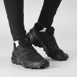 Championes Salomon Speedcross 6 de color negro, diseñados específicamente para trail running. Presentan una estructura robusta y técnica, capellada sintética y textil con refuerzos termosellados, sistema de cordones de ajuste rápido Quicklace y suela con tacos profundos para máxima tracción en terrenos difíciles.