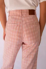 Pantalón de tela a cuadros en tonos pastel, tiro alto, silueta levemente acampanada desde la rodilla. Con cierre y botón claro, bolsillos laterales y bolsillo ojal detrás.